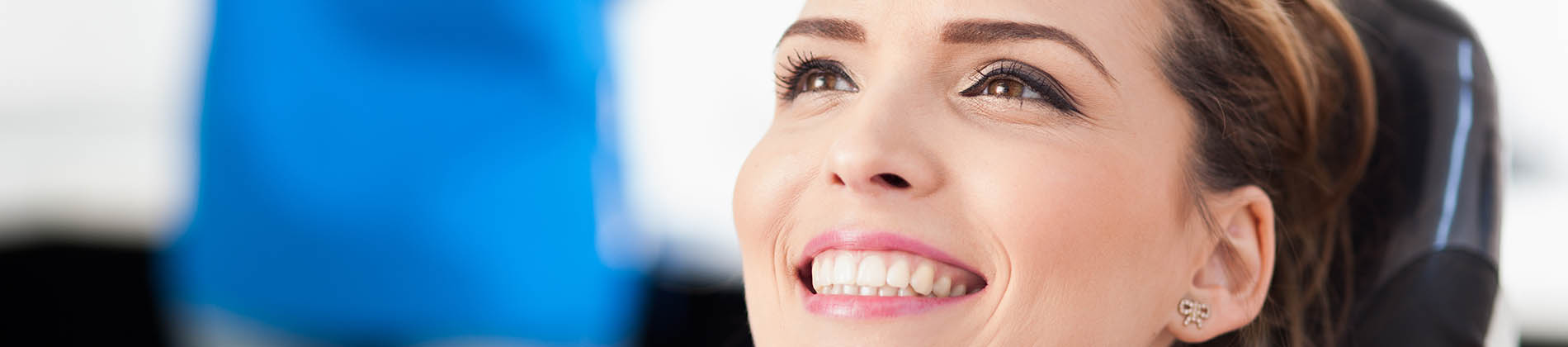 A well-lit reception area with a desk, computer monitor, and potted plant.